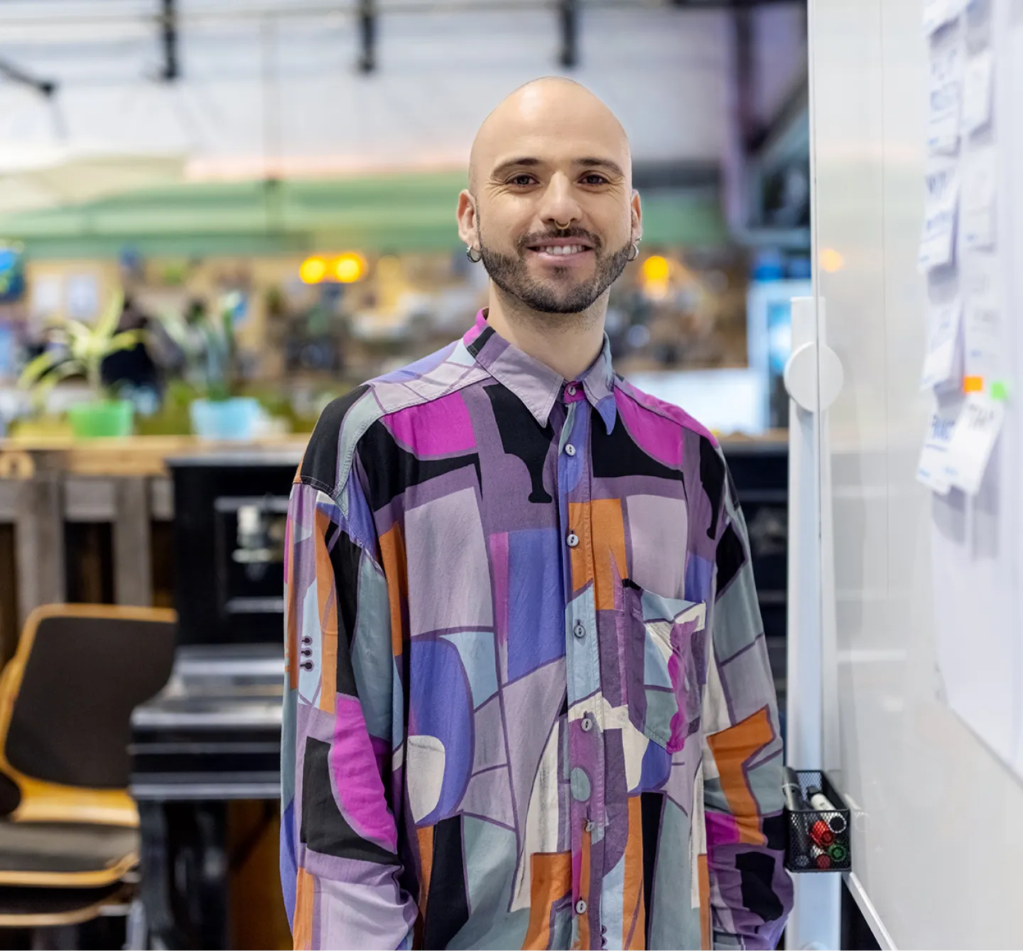 A Certified Wellness Coach wearing a patterned shirt smiles at the camera.